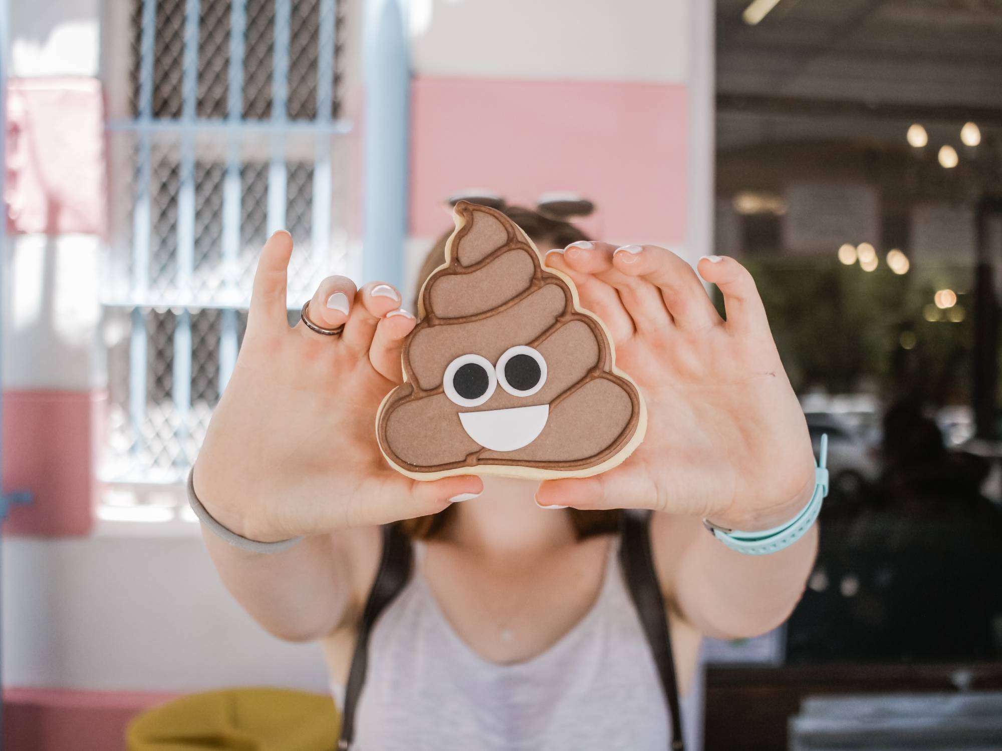 person holding poop emoji in front of their face