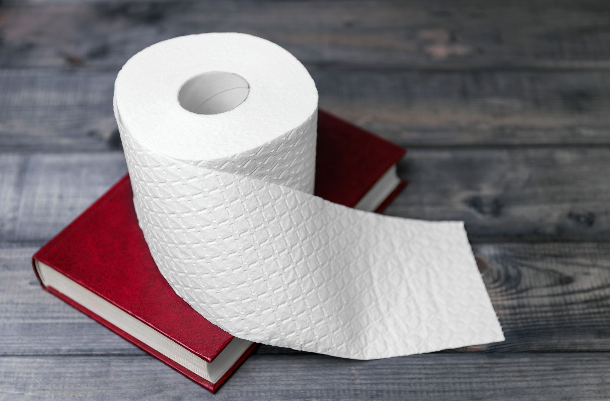 a roll of toilet paper on top of a book