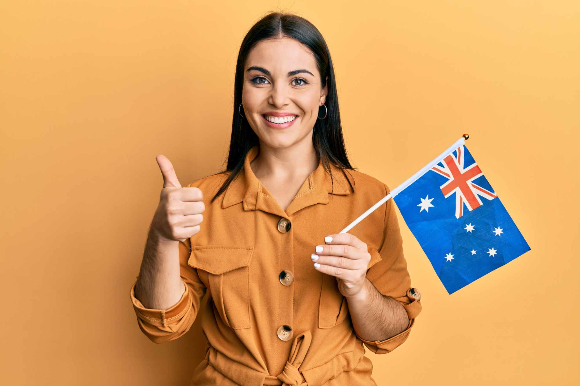 Young Australian woman holding flag and looking happy